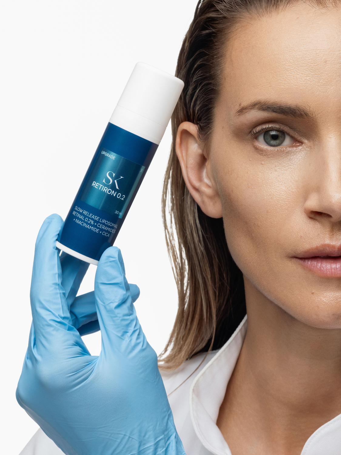 Žena sa bočicom Skintegra Retiron 0.2 limposomalnog retinala 0.2%